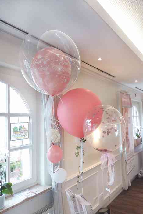 Zwei unterschiedlich rosa gefüllt klare Ballon und ein rosa Ballon mit Efeuzweig von Plambeck & Luftballonwelt.de