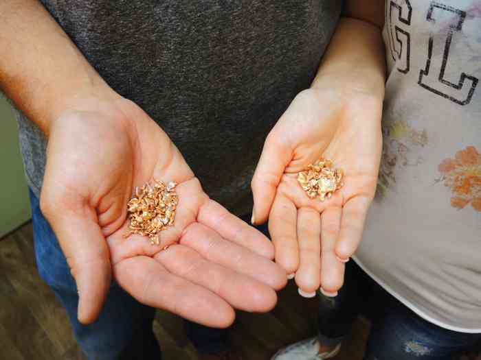 Hände halten das Gold während des Trauringkurs der Golschschmiede Schütt