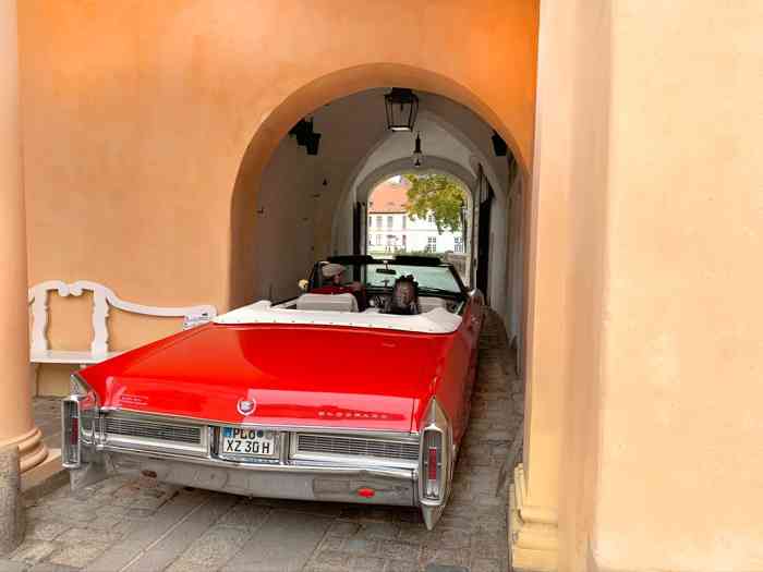 Rotes Cadillac Cabriolet fährt durch die Toreinfahrt des Schlosses Eutin.