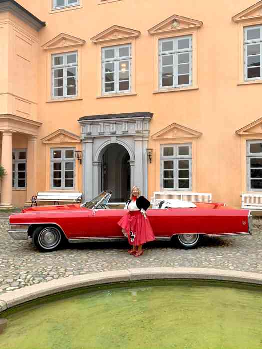 Rotes Cadillac Cabriolet im Schlosshof Eutin mit Conny Landsberger