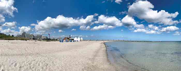 Weißer Sandstrand, blauer Himmel mit Schäfchenwolken die türkies farbene Ostsee, ein weißes Pagodenzelt - die perfekte Hochzeitskulisse.