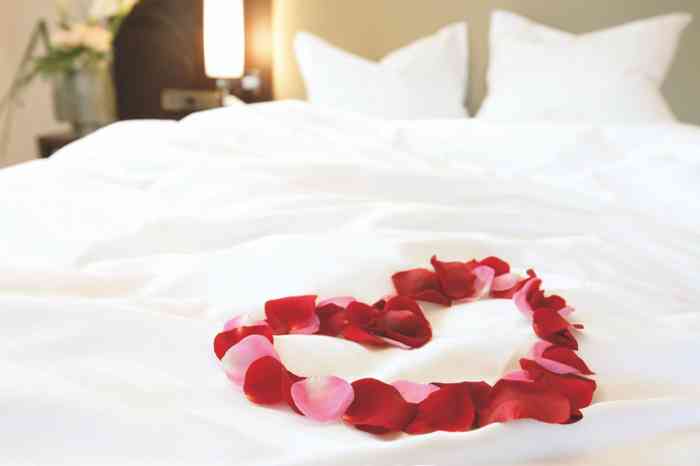 Bett mit Rosenblütenherz auf der Bettdecke der Hochzeitslocation Steigenberger Hotel Sonne in Rostock