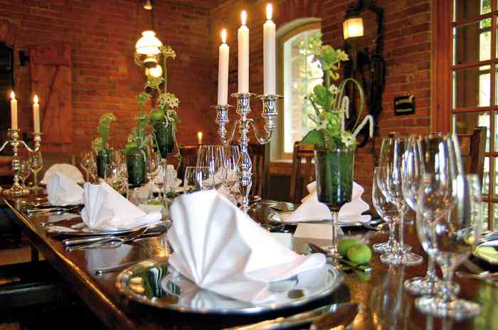 Festlich gedeckter Tisch mit silbernen Kerzenleuchtern in der Hochzeitslocation Antikhof Bissee