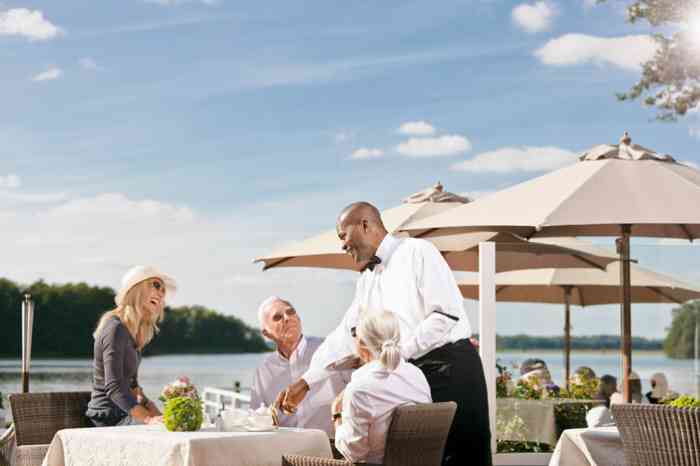 Hochzeitslocation Strauers Hotel am See. Terrasse mit Stühlen und Sonnenschirmen.