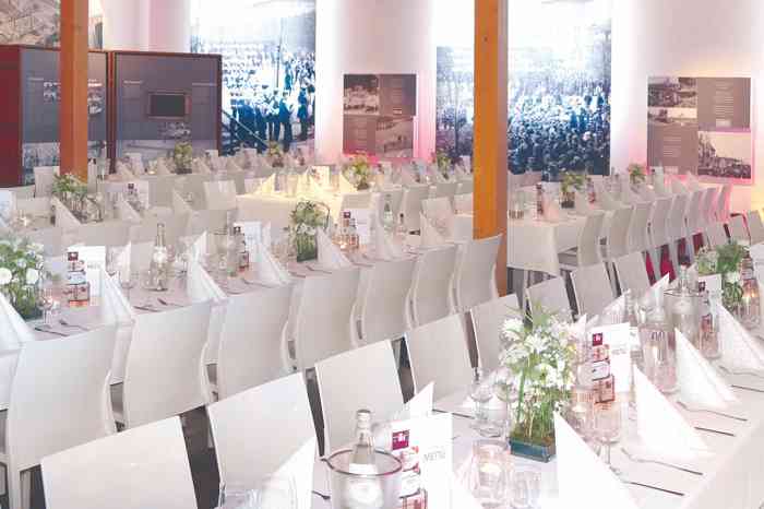 In den Ausstellungsräumen des Auswanderer Museums können Hochzeitsgesellschaften an langen Tafeln sitzen. Die weißen Designerstühle und die hell eingedeckten Tische mit schönen Stoffservietten verleihen dem Raum ein festliches Ambiente.