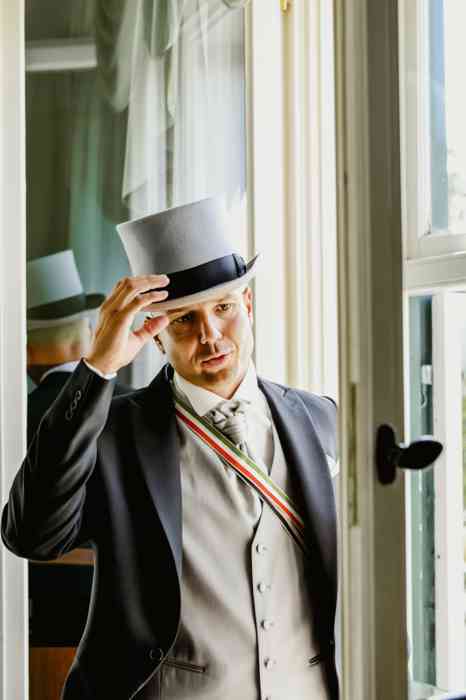 Bräutigam mit Zylinder am Fenster der Hochzeitssuite im Hotel Louis C: Jacob.