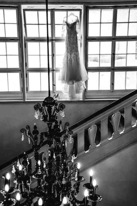 Treppenhaus der Hochzeitslocation Louis C. Jacob. Das Brautkleid hängt auf einem Bügel vor dem Fenster.