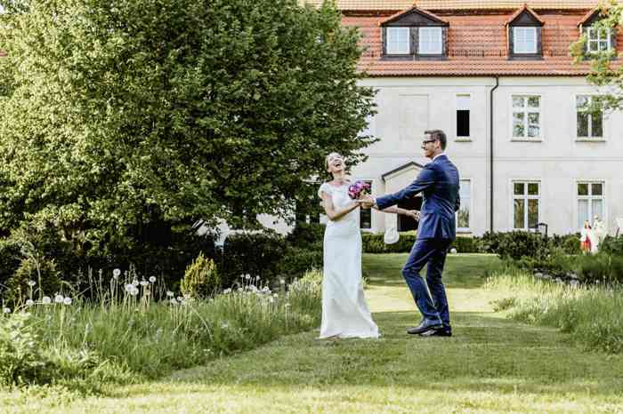 Brautpaar tanzend im Garten vor Schloss Neuenhausen.