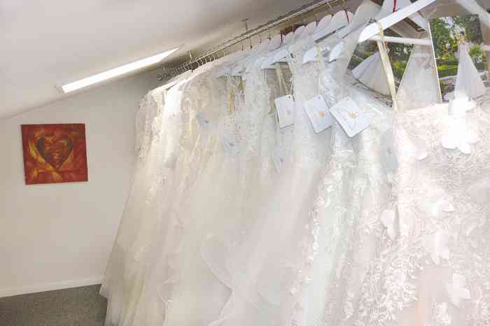 Brautkleider in Übergrößen auf einer Kleiderstange im Brautstudio.