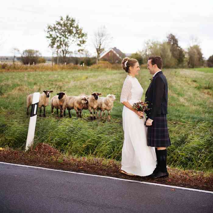 Hochzeitspaar mit Schafen. Der Bräutigam trägt einen Schottenrock