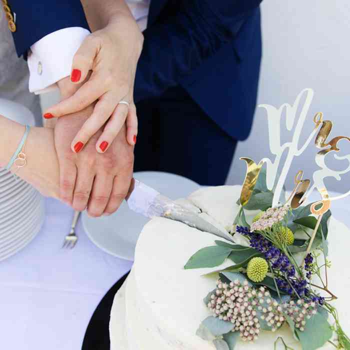 Hochzeitspaar schneidet die Hochzeitstorte an, fotografiert von Helen Fischer.