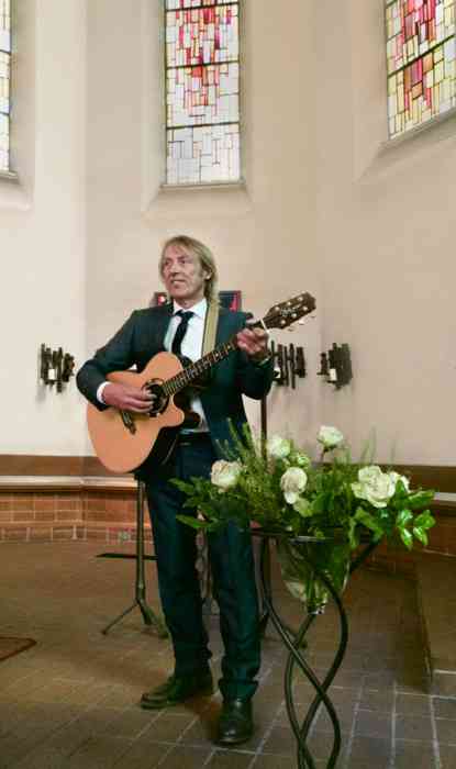 Hochzeitsmusiker Harry Tietjen mit seiner Gitarre bei einer Trauzeremonie in der Kirche.