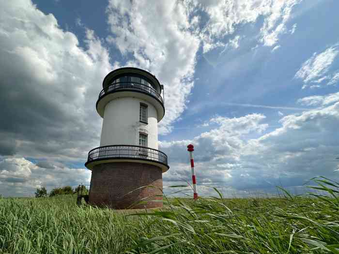 Der Alte Leuchtturm Balje inmitten des Schilfs an der Elbe. Im Hintergrund das neue Leuchtfeuer.