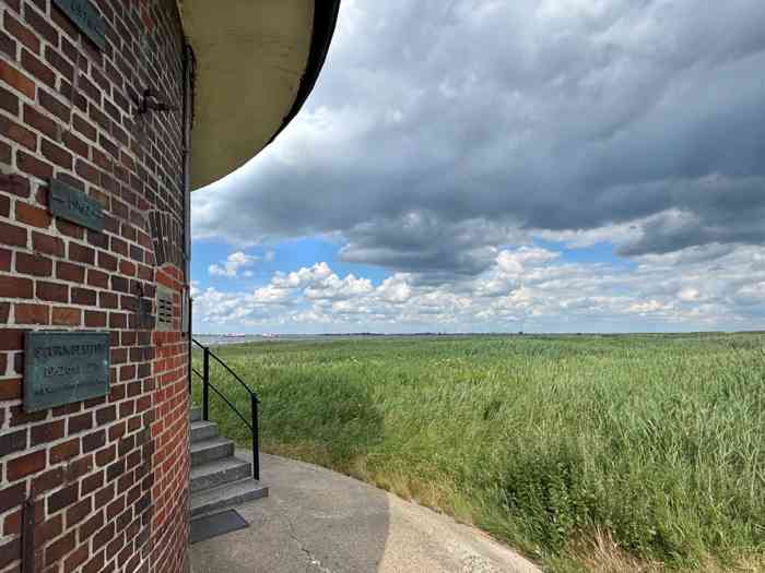 Der Alte Leuchtturm Balje inmitten des Schilfs an der Elbe. Im Hintergrund das neue Leuchtfeuer.