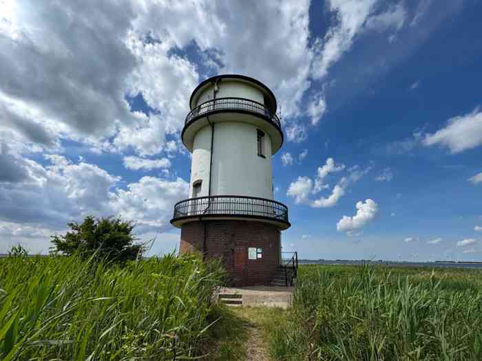 Der Alte Leuchtturm Balje inmitten des Schilfs an der Elbe. Im Hintergrund das neue Leuchtfeuer.